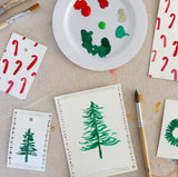 Watercolor paint palette and watercolor painting of Christmas tree and candy canes